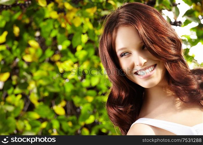 Portrait of laughing curly beauty in a summer garden