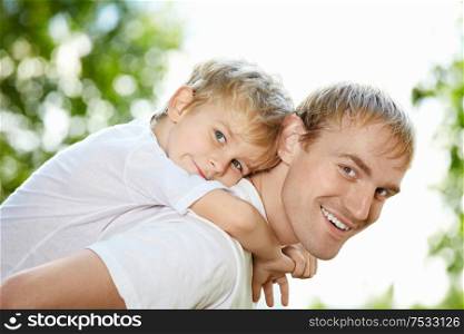 Portrait of laughing father and son piggyback