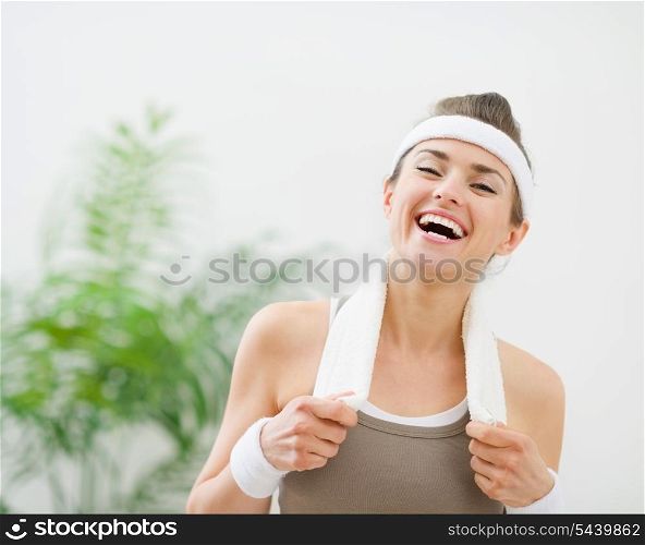 Portrait of laughing woman in sportswear with towel