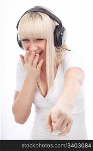 Portrait of laughing woman listening music and pointing down on an isolated white background