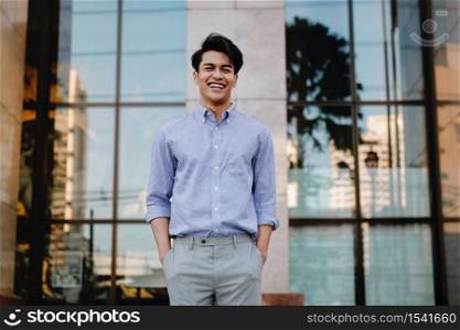 Portrait of Laughing Young Asian Businessman in the City. looking at camera. a Happy Friendly Man