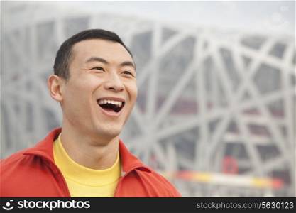 Portrait of laughing young man in park, Beijing, close-up