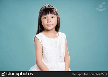Portrait of little asian princess girl in silver crown and white dress isolated on vintage green background .