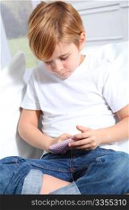 Portrait of little blond kid playing video game