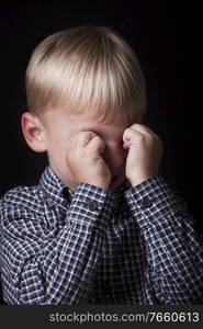 Portrait of little boy crying in studio