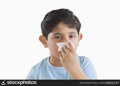 Portrait of little boy with tissue over nose