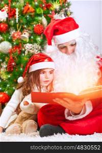 Portrait of little charming baby girl with Santa Claus reading magical Christmas story, enjoying wonderful festive fairy tale