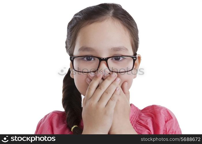 Portrait of little girl covering mouth with hands