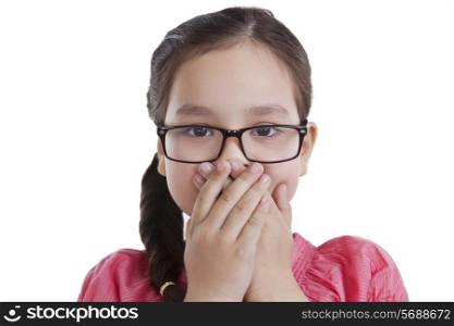 Portrait of little girl covering mouth with hands