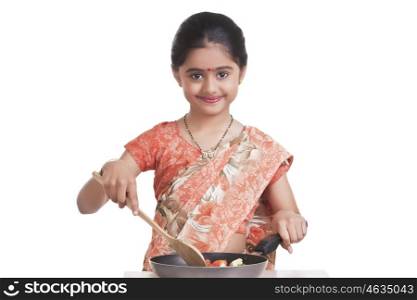 Portrait of little girl dressed as housewife cooking
