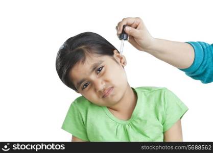 Portrait of little girl getting drops put in ear