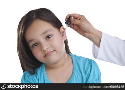 Portrait of little girl getting drops put in ear