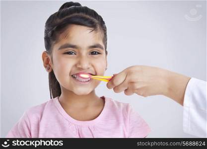 Portrait of little girl getting teeth brushed