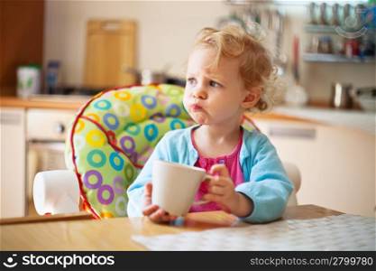 Portrait of little girl having drink in the kitchen