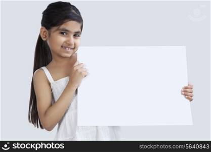 Portrait of little girl holding a white board