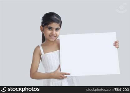 Portrait of little girl holding a white board