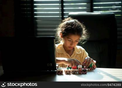 Portrait of little girl in the office room of house, They are having fun playing with toy trains