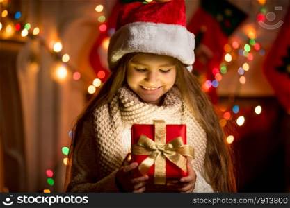 Portrait of little girl looking at open box with Christmas present