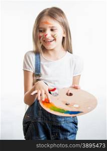 Portrait of little girl painted by different colors posing at studio