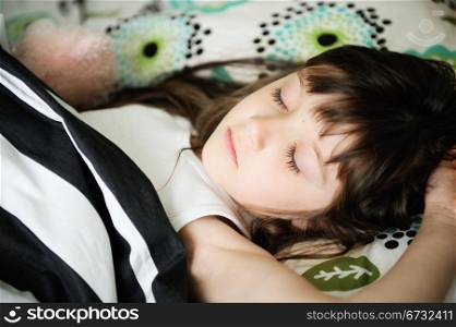 Portrait of little girl sleeping in bed in early morning