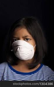 Portrait of little girl wearing a medical mask used for virus protection