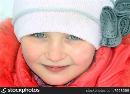 portrait of little girl with blue eyes in the original winter cap