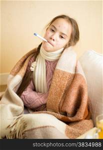 Portrait of little girl with chickenpox holding thermometer in mouth