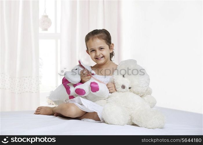 Portrait of little girl with teddy bear in bedroom