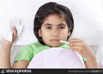 Portrait of little girl with thermometer in mouth