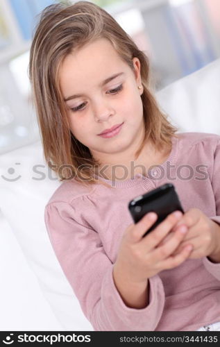 Portrait of little girl writing short message on mobile phone