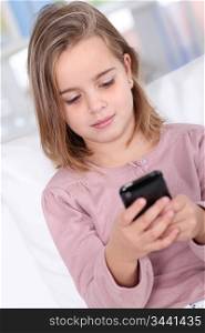 Portrait of little girl writing short message on mobile phone
