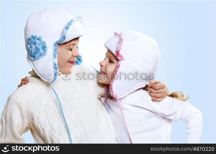 Portrait of little kid in winter wear against blue background