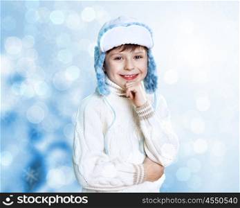 Portrait of little kid in winter wear against snow background