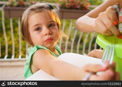 Portrait of little small girl blonde hair wearing green dress in summer day