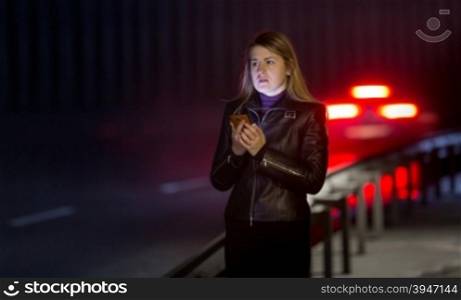 Portrait of lonely woman posing at dark highway
