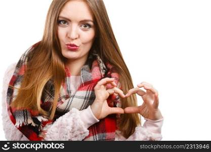 Portrait of long hair girl in bright sweater and warm woolen big scarf making heart shape by hands. Winter fashion.. Woman wearing scarf making heart shape by hands