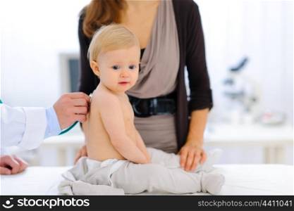 Portrait of lovely baby being checked by pediatrician using a stethoscope &#xA;