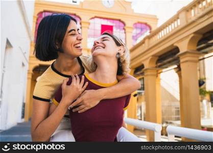 Portrait of lovely lesbian couple spending time together and having fun at the street. LGBT concept.
