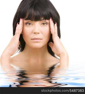 portrait of lovely woman in water touching her temples