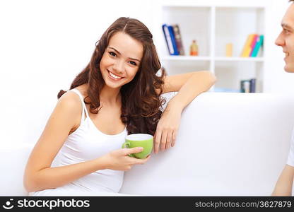 Portrait of lovely young woman having cup of tea at home