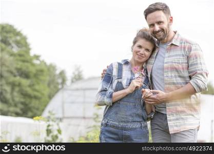 Portrait of loving couple standing together at farm against sky