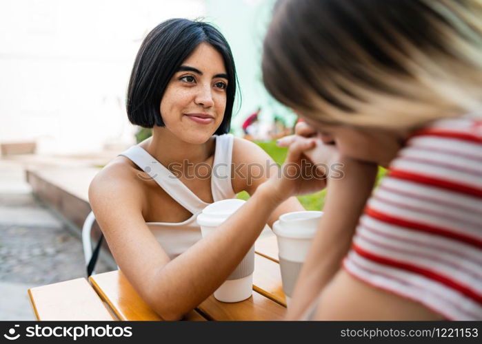 Portrait of loving lesbian couple holding hands and having a date at coffee shop. LGBT., love and relationship concept.