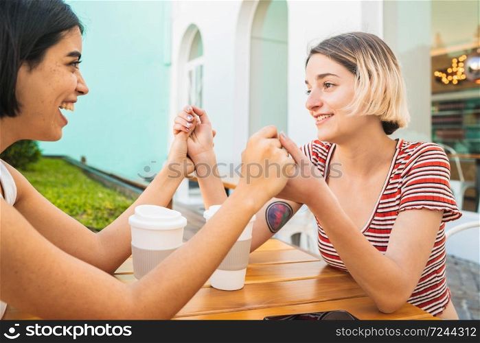 Portrait of loving lesbian couple holding hands and having a date at coffee shop. LGBT., love and relationship concept.