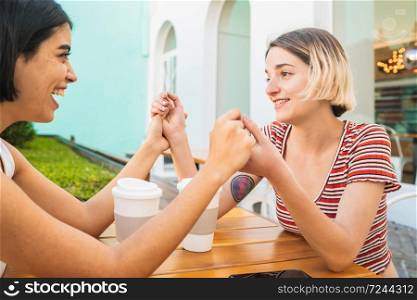 Portrait of loving lesbian couple holding hands and having a date at coffee shop. LGBT., love and relationship concept.