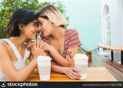 Portrait of loving lesbian couple spending good time together and having a date at coffee shop. LGBT concept.