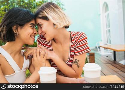 Portrait of loving lesbian couple spending good time together and having a date at coffee shop. LGBT concept.