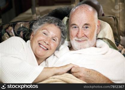 Portrait of loving senior couple in bed together.