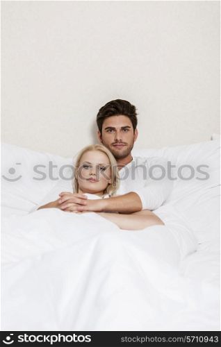 Portrait of loving young couple resting in bed
