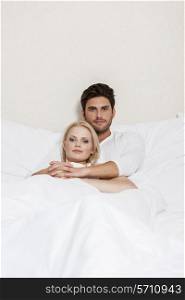 Portrait of loving young couple resting in bed