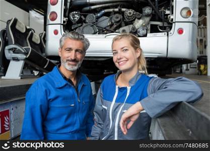 portrait of male and female mechanics in the pit